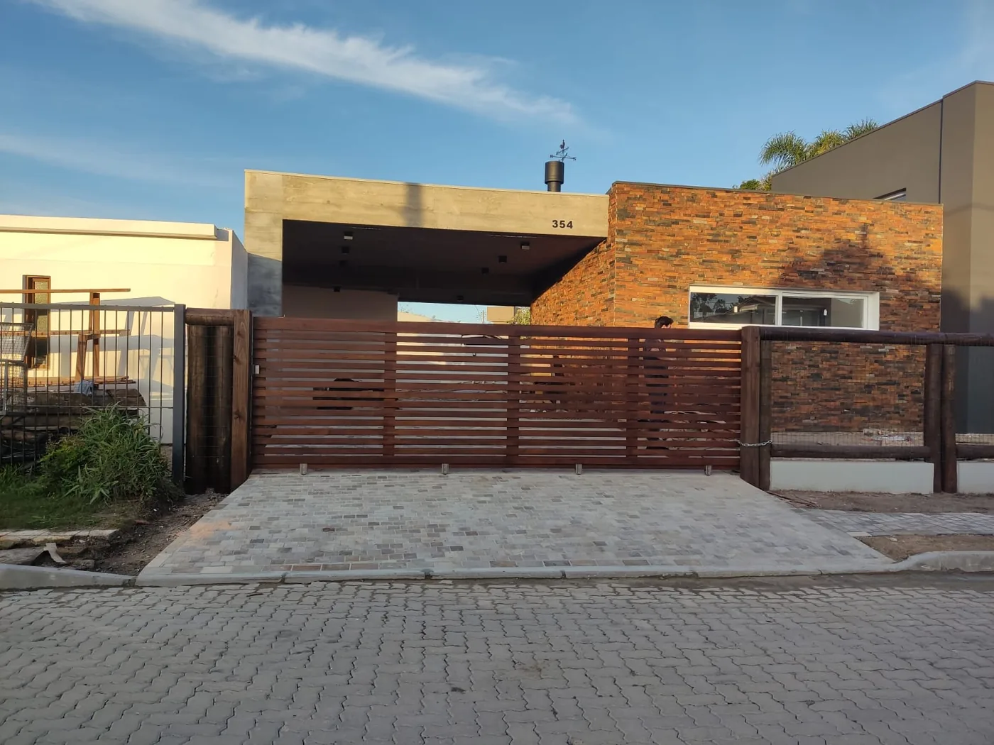 Portão madeirado moderno em fachada residencial